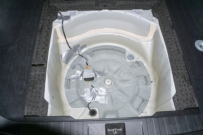 Photograph of Hopkins plug in vehicle wiring harness with 4 pole connector inside 2010 Subaru Outback spare tire well before protective conduit was installed.